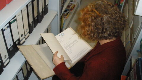 Archivarin bei der Durchsicht von Unterlagen.